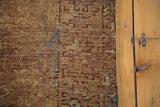Distressed bronze and chestnut pile texture with subtle aqua geometric motifs.