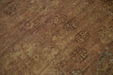 Distressed pile texture with muted geometric motifs in bronze, chestnut, and aqua tones.