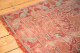 Textured pile and faded rose field of a distressed vintage Oushak carpet, showing early 20th century motifs.