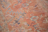 Textural detail of the distressed rose field with faded light blue and charcoal motifs.