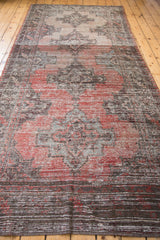 Distressed Oushak runner detail, with faded rose grapefruit, blue geometric motifs, and abrash.
