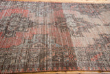 Worn pile and faded geometric pattern in muted rose, brown, and blue tones.