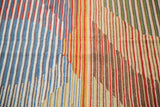 New Kilim rug showcasing striated blue, red, green, and brown abstract patterns.
