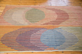 Modern kilim rug detail: striated abstract designs in red, blue, green, yellow, and beige.