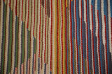 New Kilim rug close-up: textured weave with vibrant, striated color blocks.