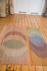 Modern abstract New Kilim rug with striated blue, red, yellow, and green patterns.