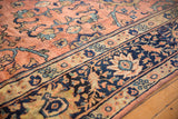 Vintage Mahal carpet detail with rose terracotta field, navy border, and serrated teal leaves.