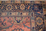 Mahal rug corner detail: rose terracotta field, navy border, teal serrated leaves.