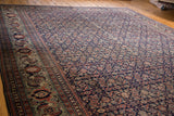 Distressed Tabriz carpet, detailed Herati pattern on navy field, and muted green border with leaves.