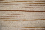 Kilim rug texture with bands of bronze, ivory, and soft earth tones.