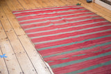 Detail of hand woven vintage Moroccan Kilim showing striated red and muted grey bands.