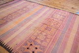 Decorative geometric bands and striated colors of mauve, orange, and pink on vintage Kilim.