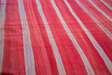Hand woven texture of the vintage Moroccan Kilim with rich red, ivory, and mauve stripes.