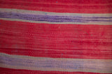 Hand-woven Moroccan kilim texture, highlighting bands of rich red, ivory, and mauve.