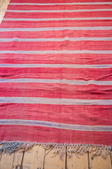 Hand-woven fringe detail on vintage Moroccan Kilim with rich red, ivory, mauve bands.