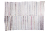 Hand-woven striped rug with off-white, grey, dusty rose, blue, and visible seam.