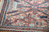 Faded copper, navy, aqua blue floral and animal motifs on a vintage Persian Bidjar rug.