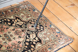 Scalloped floral motifs in blush, navy, sky blue, copper green on a Persian vintage Sarouk rug.