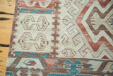Vintage Kilim rug detail showing geometric tree designs in faded aqua and cochineal red.