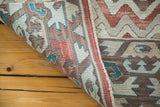 Folded vintage Turkish Kilim rug revealing flat weave texture and faded geometric patterns.