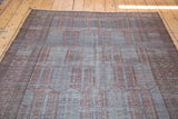 Distressed vintage Belouch carpet with faded copper, grey, and charcoal cartouche design.