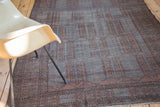 Distressed Belouch carpet showing faded copper orange and blue-gray plant cartouches.