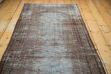 Distressed Persian Malayer runner texture with faded intricate border and moss, charcoal, rust tones.