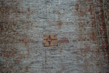 Distressed Malayer runner's faded texture, revealing red geometric motif.