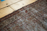 Vintage Malayer runner's distressed texture and intricate border, featuring soft charcoal and ivory.