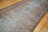 Distressed texture and intricate border with charcoal, moss green, ivory tones.