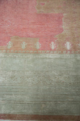 Distressed Ghiordes carpet showing raspberry field, geometric tridents, and sea foam green border.