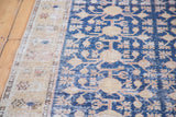 Distressed Khotan runner with navy blue field, saffron gold geometric pomegranate motifs, and beige border.