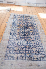 Distressed navy field with geometric floral motifs transitioning to a light border.