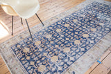 Distressed Khotan runner showing navy blue field, saffron gold, and ivory floral motifs.