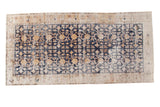 Distressed hand-knotted Khotan runner with navy blue geometric field and saffron gold floral motifs.
