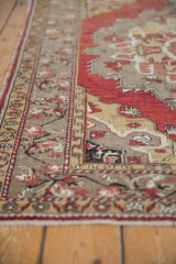 Distressed vintage Oushak rug border with cinnabar red and gold patterns.