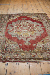 Distressed fringe and muted floral border of the vintage Oushak rug.