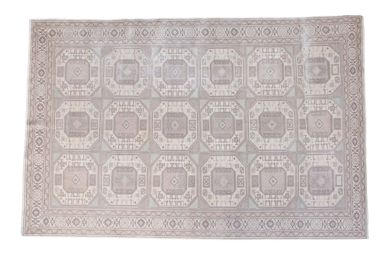Distressed Turkish Kaisary carpet with geometric guls in pastel blush, seafoam green, and ivory.