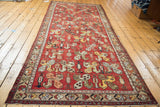 Vintage Oushak runner's madder red field with tribal stylized rectilinear pinwheel design.