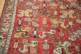 Vintage Oushak runner with tribal stylized pinwheel boteh motifs on madder red, yellow, and blue.