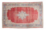 Distressed Oushak carpet featuring a cherry red field, star medallion, and grey beige patterns, 7'9