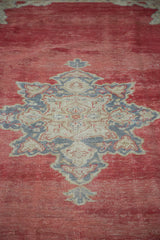 Distressed cherry red Oushak carpet pile featuring star medallion in grey and beige.