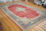 Distressed vintage Oushak carpet with deep cherry red field and decorative grey-beige border.