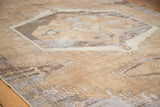 Angled view of the distressed Oushak carpet's geometric medallion, with faded earth tones.
