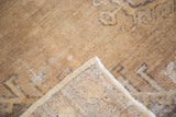Distressed brown Oushak rug pile texture with visible hand knotted backing.