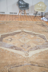 Distressed Oushak carpet's central geometric medallion and tribal weave with faded earth tones.