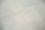 Distressed Oushak carpet pile showing textured re-piling in soft ivory and peach.