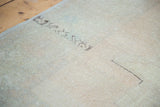 Distressed hand-knotted pile texture in soft peach and apricot tones.