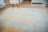 Distressed hand-knotted Oushak carpet, its faded apricot field showing re-piling.