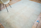 Distressed vintage Oushak carpet showing faded peach apricot field with re-piling texture.